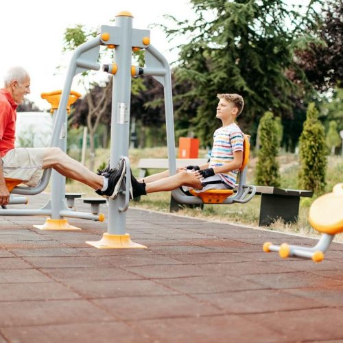 dziadek z wnuczkime na zewnętrznej siłowni